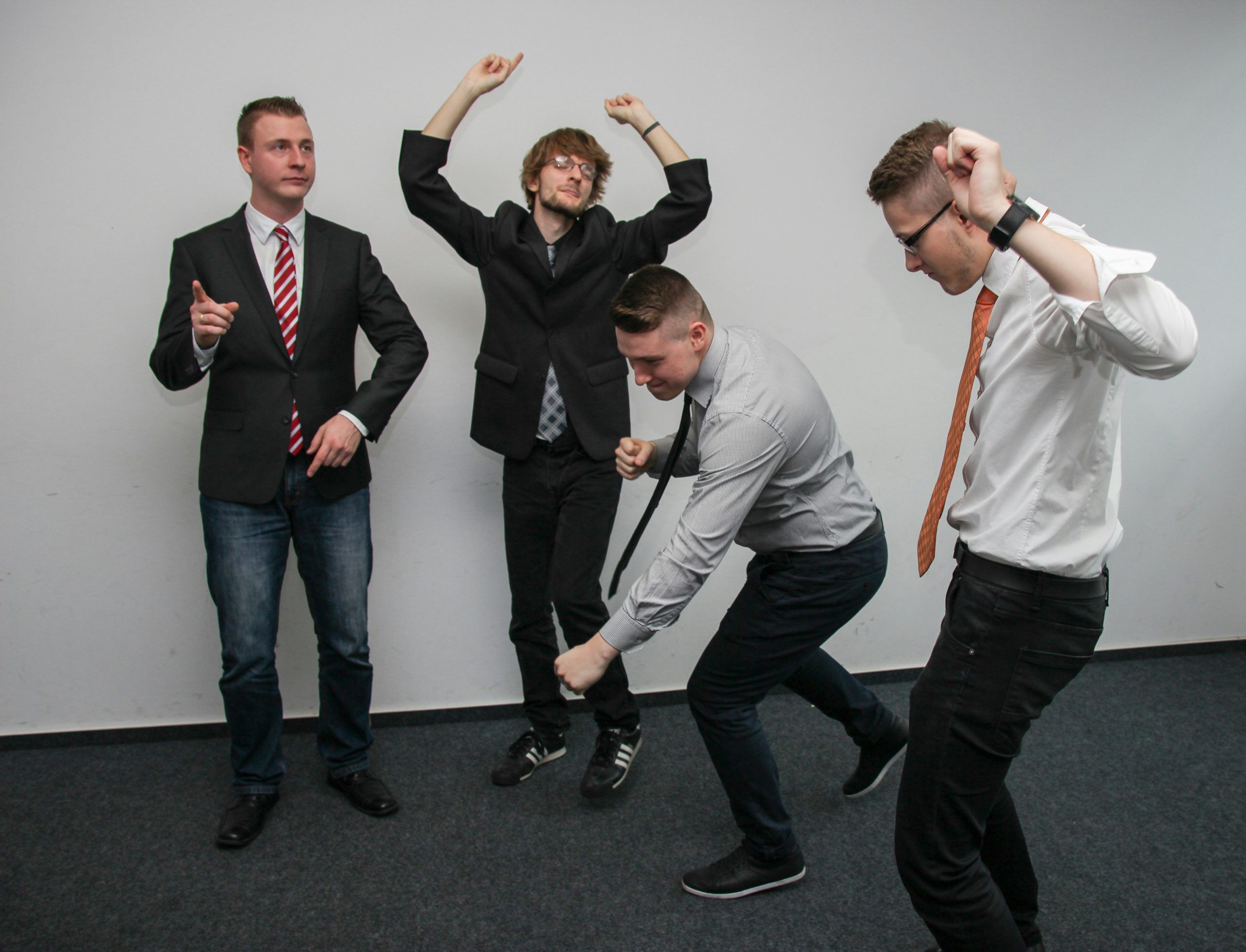 Four businessmen dancing in the office.
